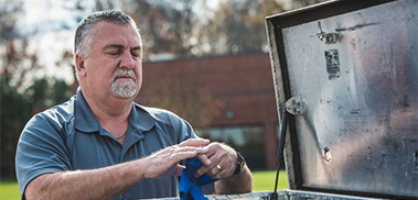 An All Exterminating worker going through their toolbox in their work truck.